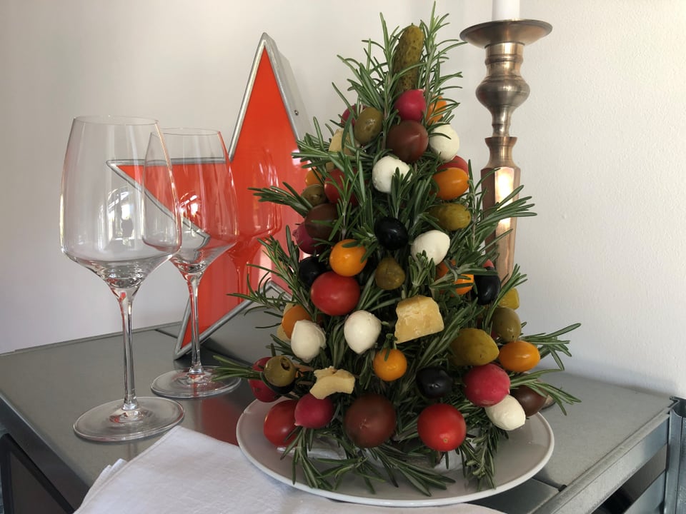 Ein Weihnachtsbaum zum Essen, die Kugeln sind aus Oliven, Cherry-Tomaten, Mozzarella-Perlen, Radieschen