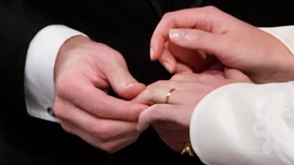 Männerhand hält einen Frauenhand, an der ein Ring steckt.