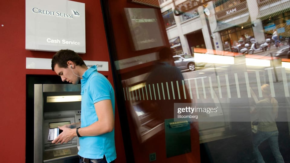Mann steht am Geldautomat