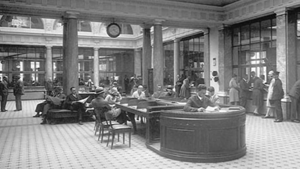 Schwarzweissaufnahme einer Bank-Schalterhalle um die Jahrhundertwende.