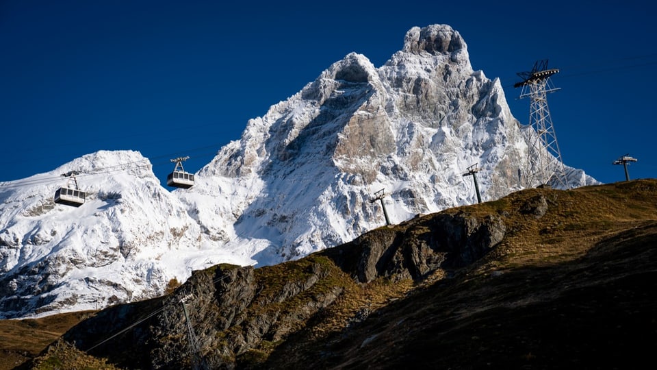 Apere Skipisten im Vordergrund, verschneiter Gipfel im Hintergrund
