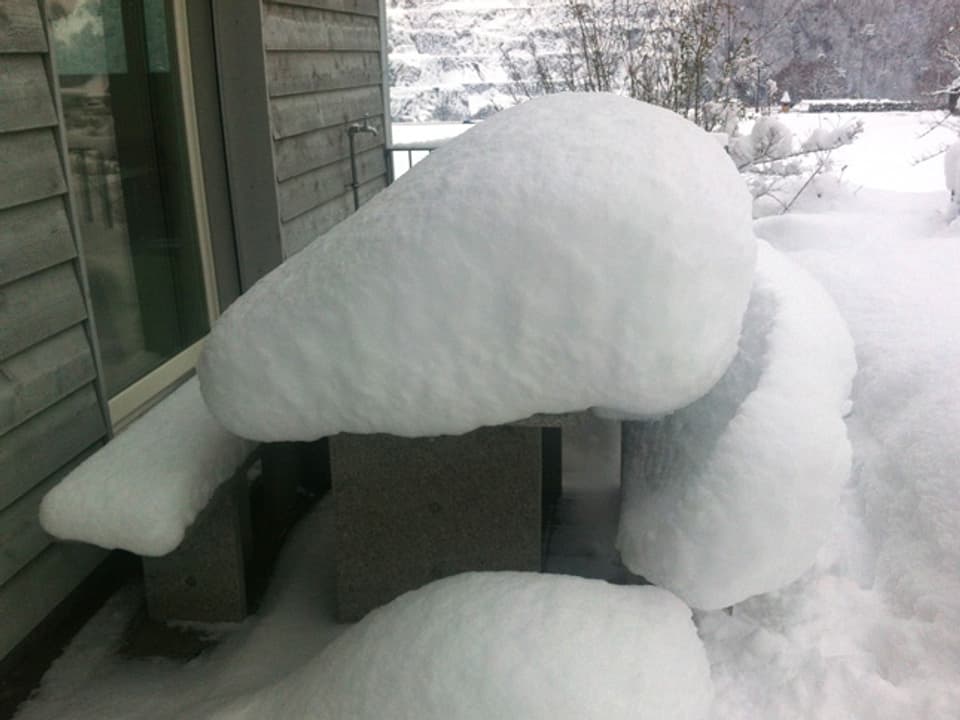Schneepilze auf den Tischen und Stühlen eines Sitzplatzes.