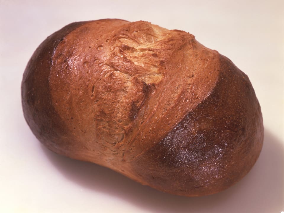Ein Laib dunkel gebackenes Brot.