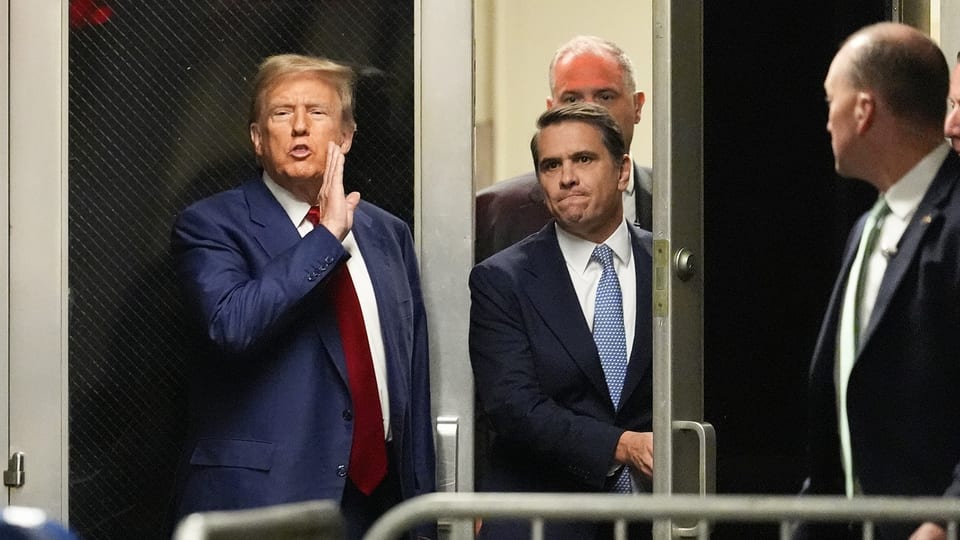 Trump hebt die Hand neben seinen Mund und äussert sich zur Anhörung.
