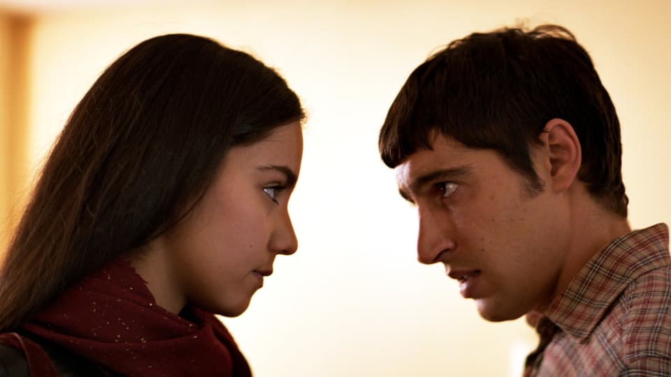 Eine junge Frau und ein junger Mann schauen sich an. 