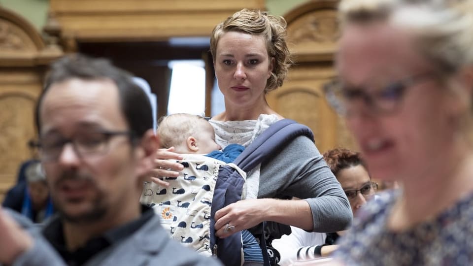 Die Grüne Nationalrätin Irène Kälin sitzt mit ihrem Baby an der Brust im eidgenössischen Parlament.