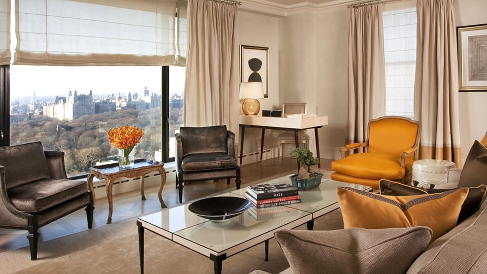 Ein nobles Wohnzimer mit bequemen Sesseln und einem Sofa. Ein grosses Fenster mit Blick auf den Central Park.