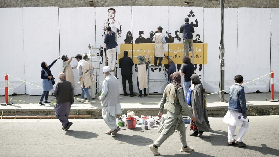 Menschen vor einer Wandmalerei