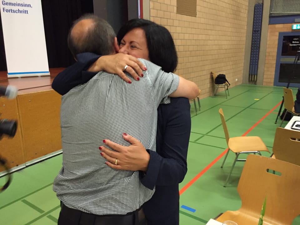 Meister und ihr Mann umarmen sich.