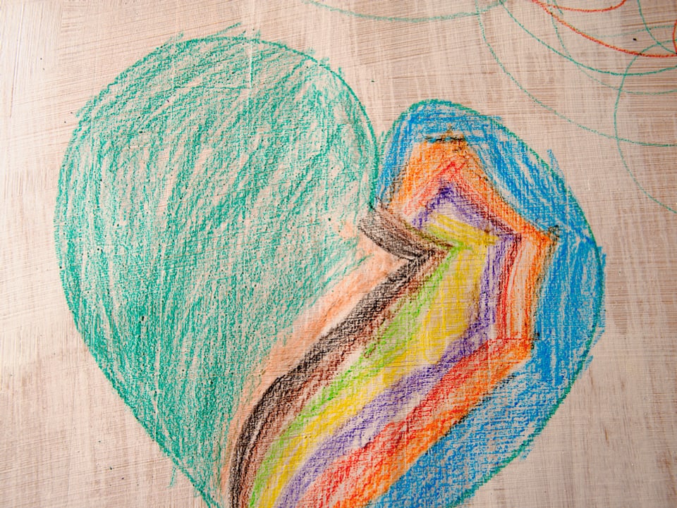 Ein mit Farbstiften gezeichnetes Herz, das auf der linken Seite grün und auf der rechten Seite ziemlich bunt ist.