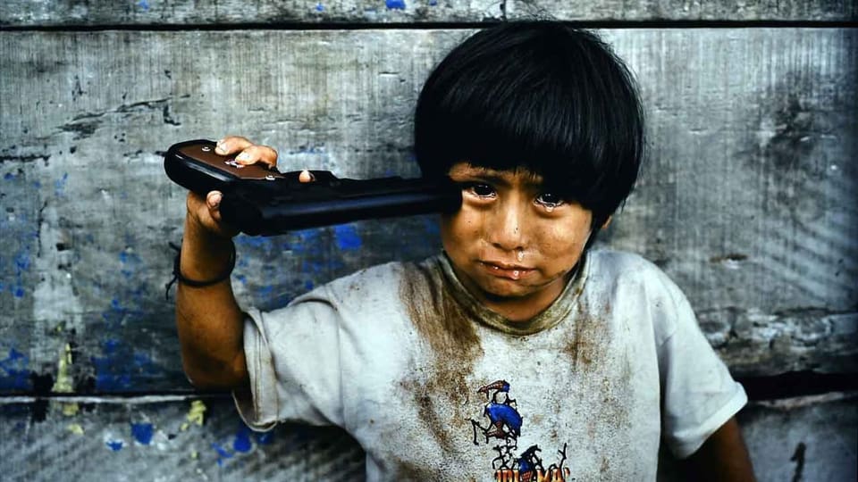 Ein Kind hält sich eine Pistole gegen den Kopf.