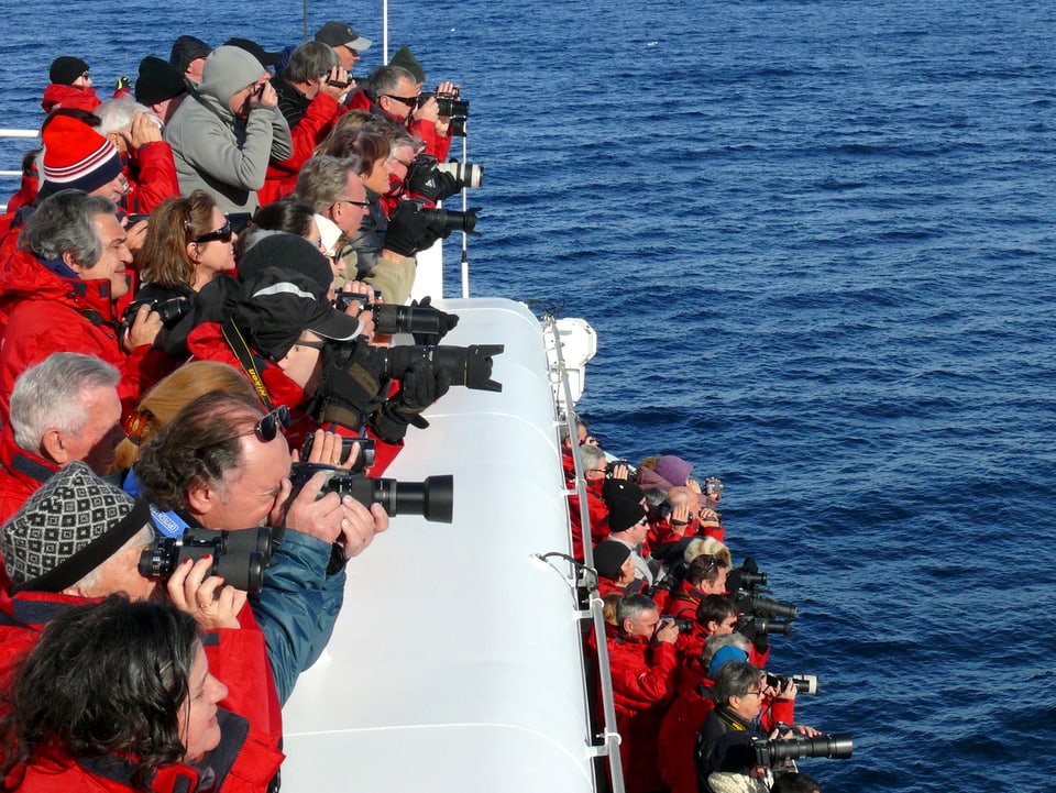 Dicht zusammengedrängt stehen Touristen an Bord, in der Hand Kameras mit langen Objektiven.