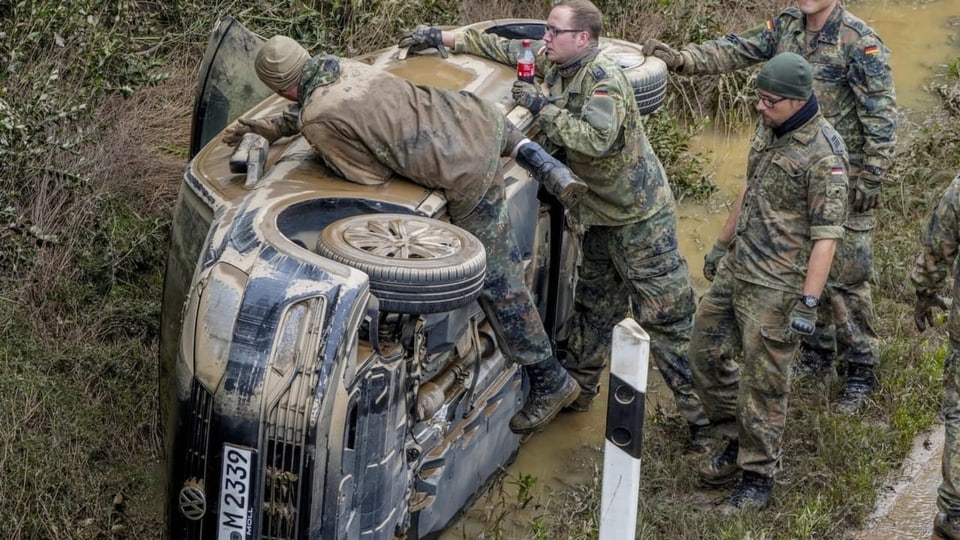 Handarbeit: Soldaten bei der Bergung eines gekippten Autos bei Erftstadt.