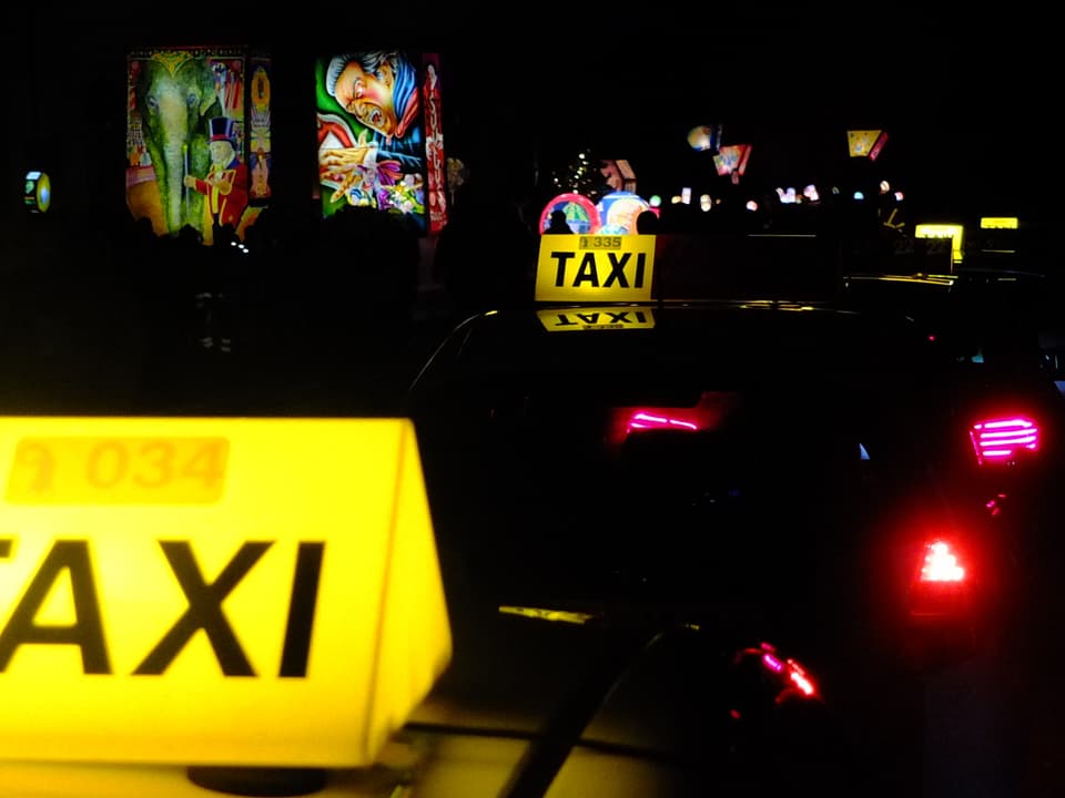 Beleuchtete Taxischilder und Fasnachtslaternen.