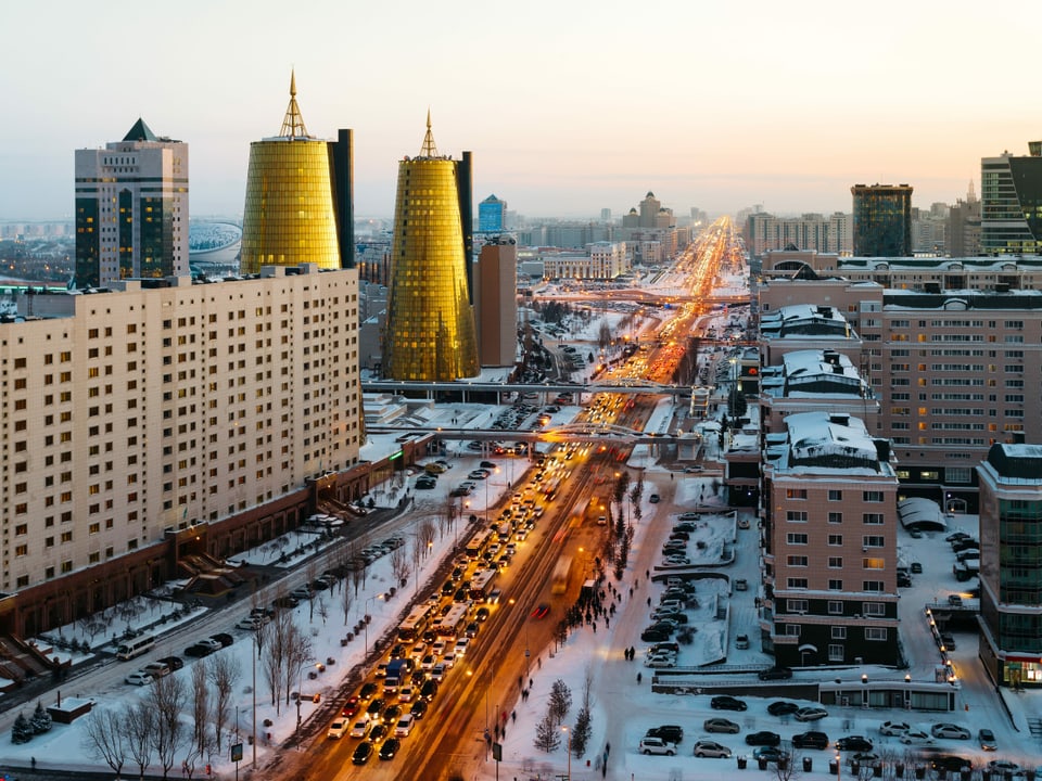 Blick von oben auf eine Strasse in Astana, Schnee, Hochhäuser im Hintergrund