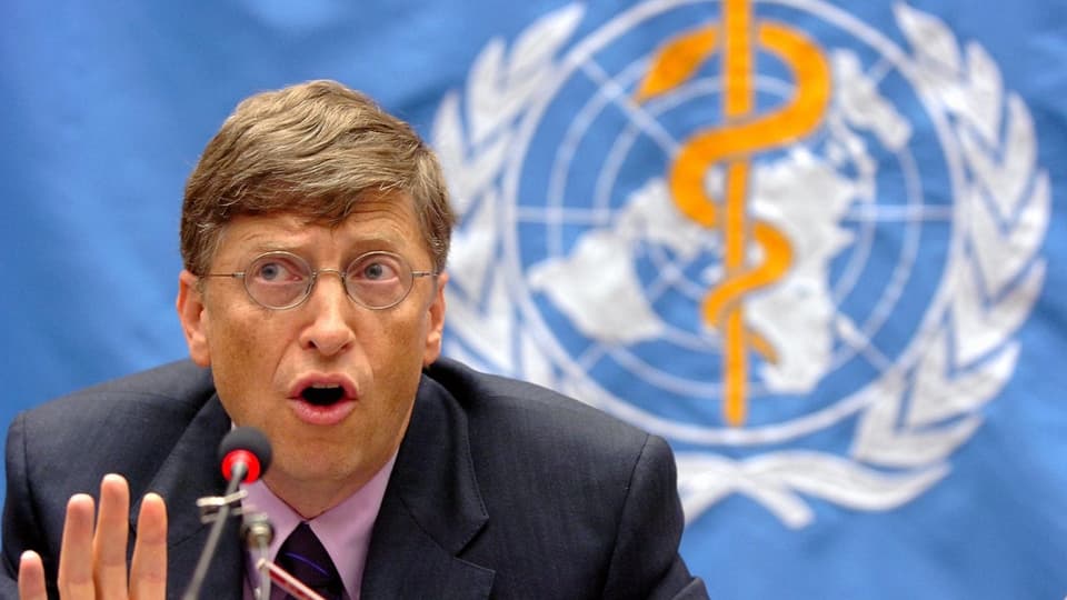 Microsoft-Gründer Bill Gates bei einer Ansprache vor einer Flagge mit WHO-Logo