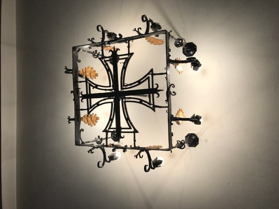 Die Deckenlampe im Vorraum der Kirche hat die Form eines Eisernen Kreuzes.