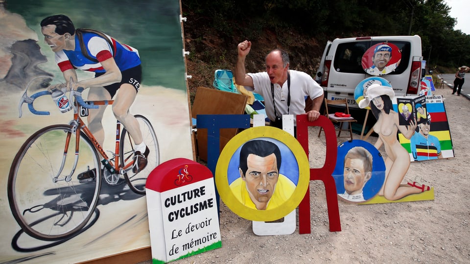 Ein Maler und Radsport-Fan präsentiert seine Bilder am Strassenrand.