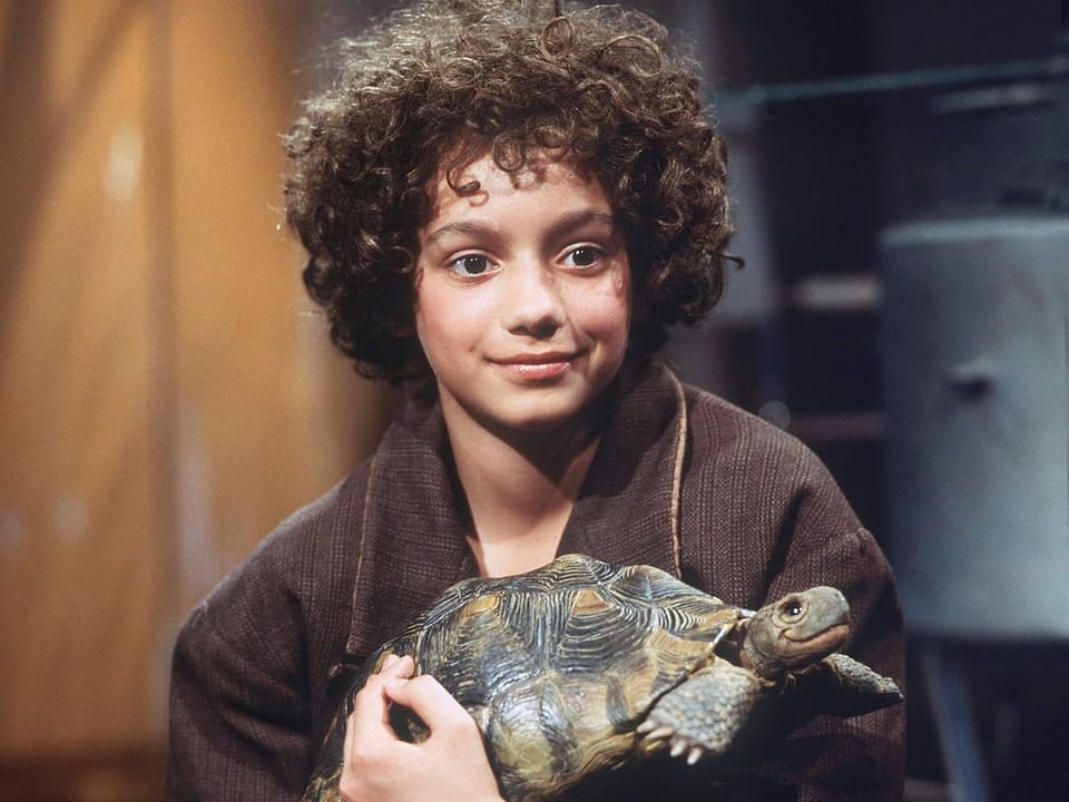 Filmszene: Mädchen mit krausem Haar hält eine Schildkröte
