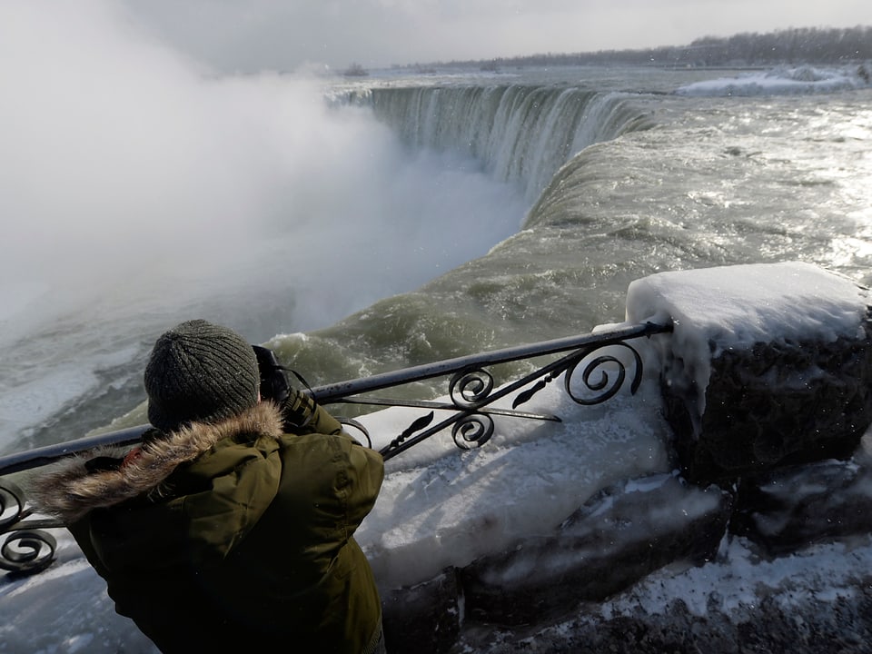 Eine Person fotografiert die Niagarafälle.
