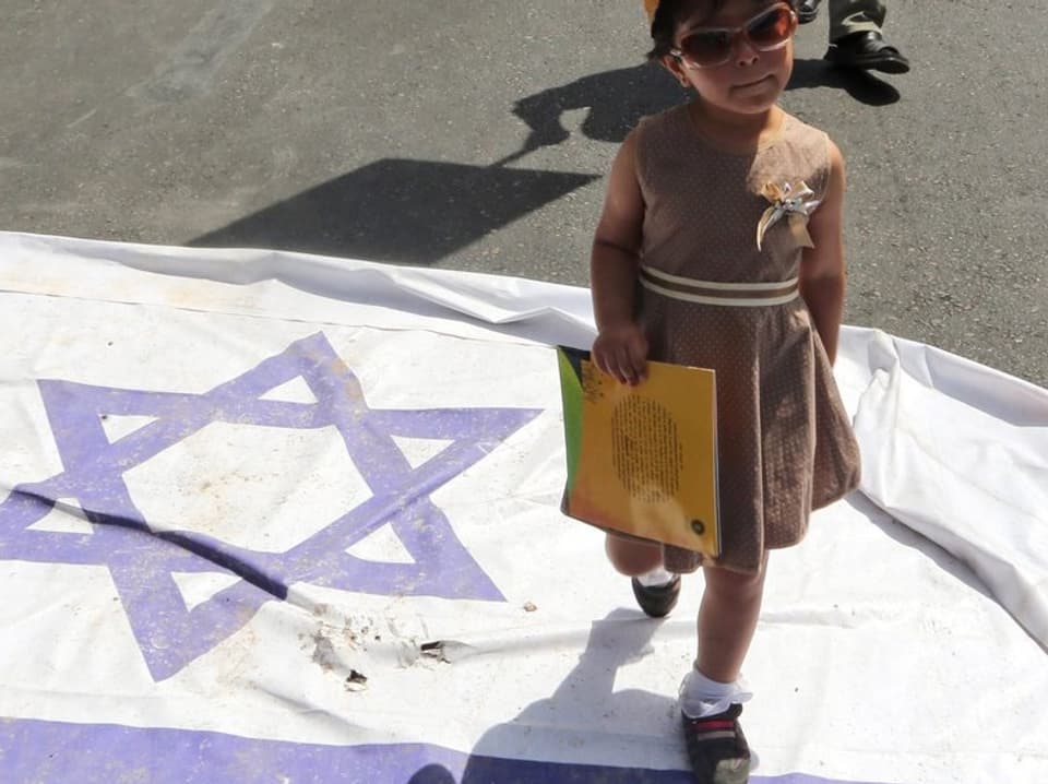 Kind läuft über Israel-Flagge.