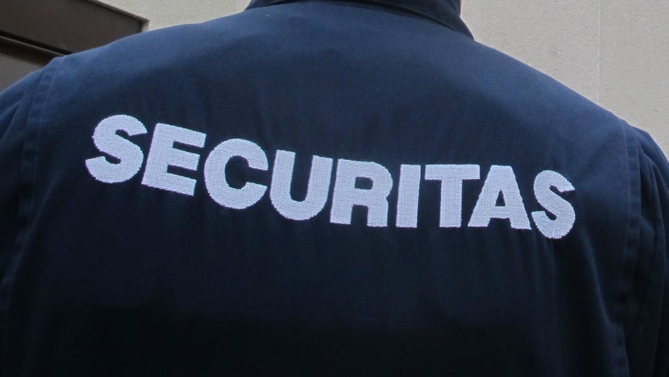Rückenansicht eines Securitas-Mitarbeiters, auf dem Rücken seiner Uniform ist das Firmenlogo zu sehen.