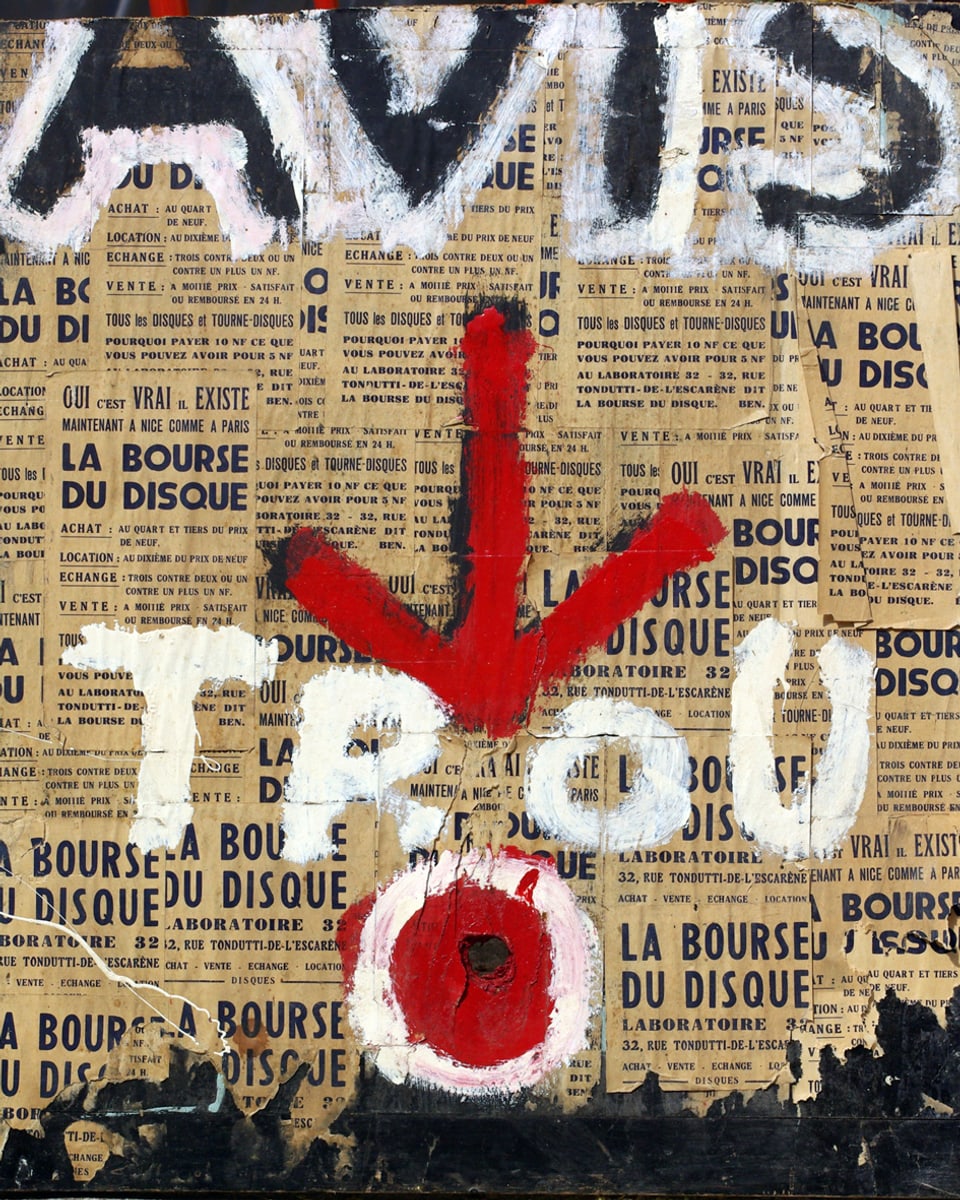 Collage mit Zeitungspapier. Darauf steht in schwarzer und weisser Schrift "Avis" sowie "TROU", dazwischen ein roter Pfeil, darunter ein roter Kreis. 