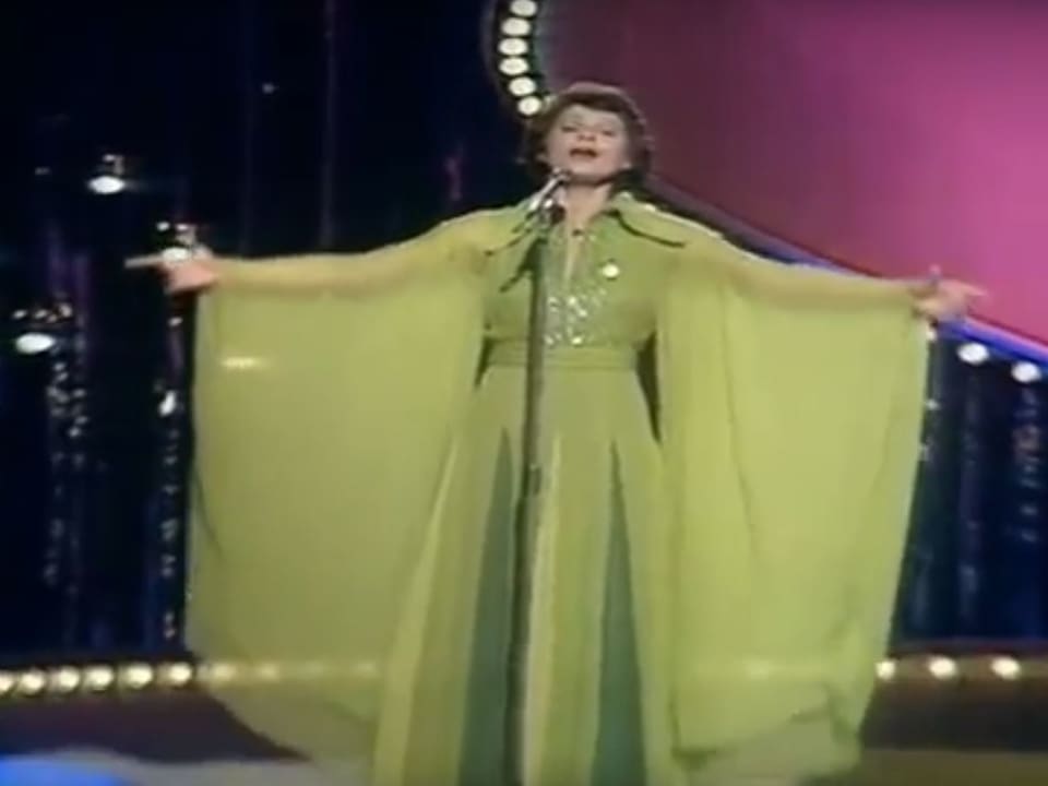 Frau mit wallendem, grünen Kleid. auf Bühne.