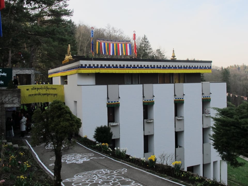 Tibetische Gebetsfahnen schmücken ein weisses Haus