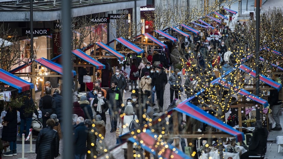 Tessin: Menschen tragen Masken an einem Weihnachtsmarkt.