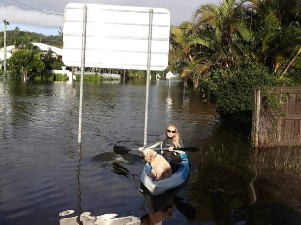 Überflutete Strasse mit Frau in Kayak