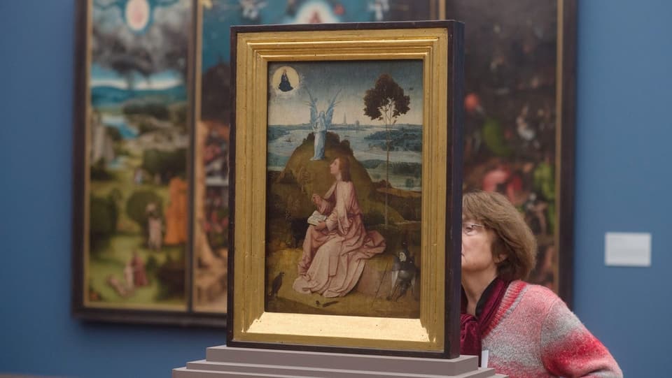 Eine Besucherin wandert durch eine Ausstellung zu Hieronymus Bosch in Berlin.