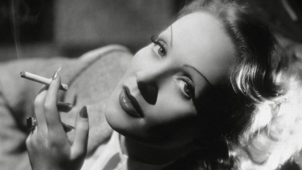 Porträt von Marlene Dietrich mit laszivem Blick und Zigarette.