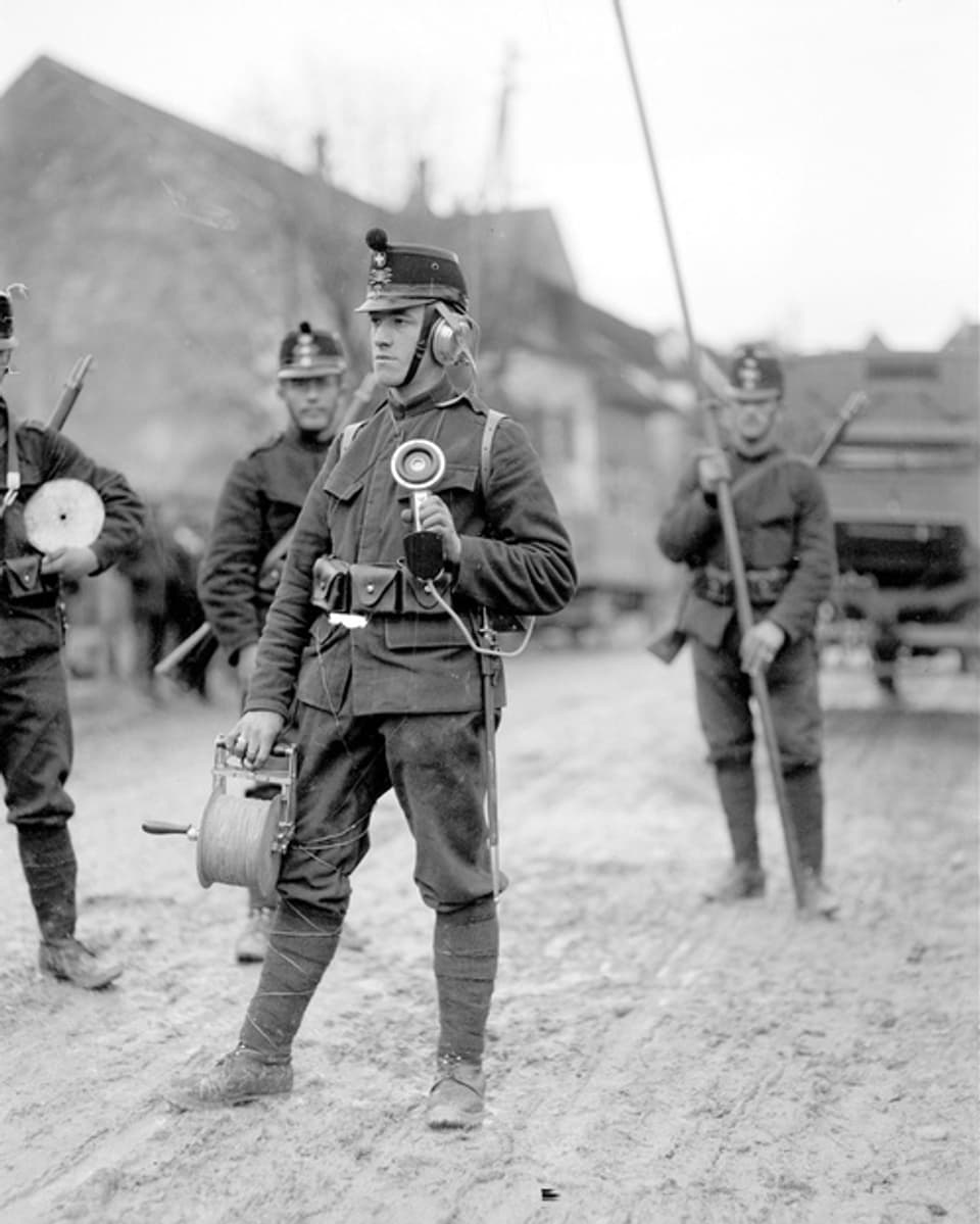 Historisches Bild eines Schweizer Soldaten mit Kabelrolle in der Hand. 