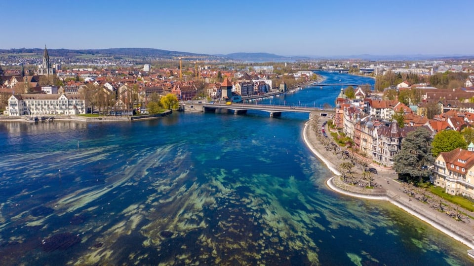 Ein Delta (blau-grün), ein Flus, der druch ein Städtchen fliesst bei schönem Wetter.