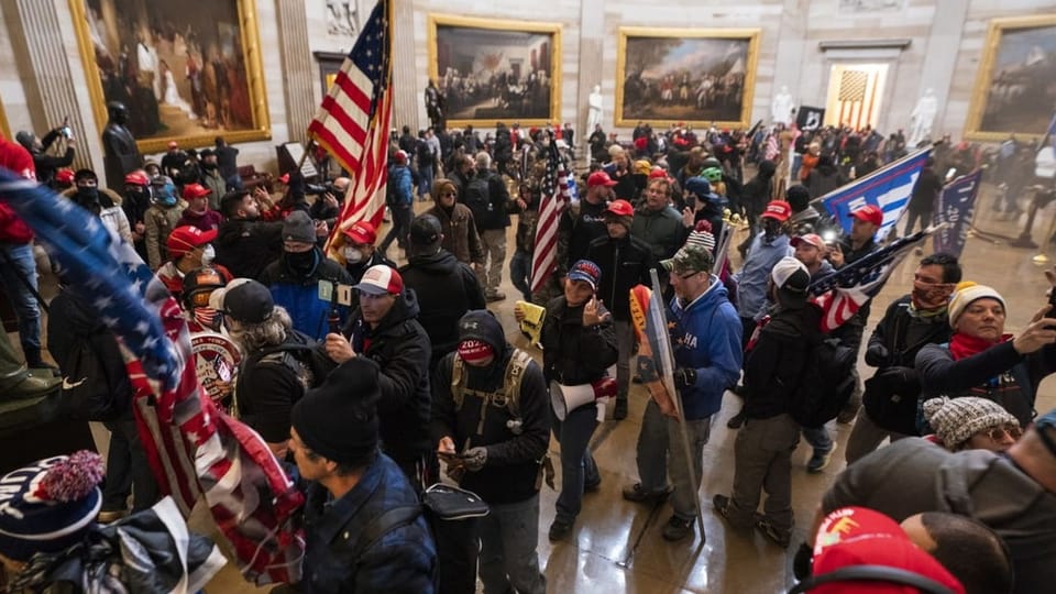 Ein Bild aus dem Kapitol mit etlichen Personen, die dieses stürmen.