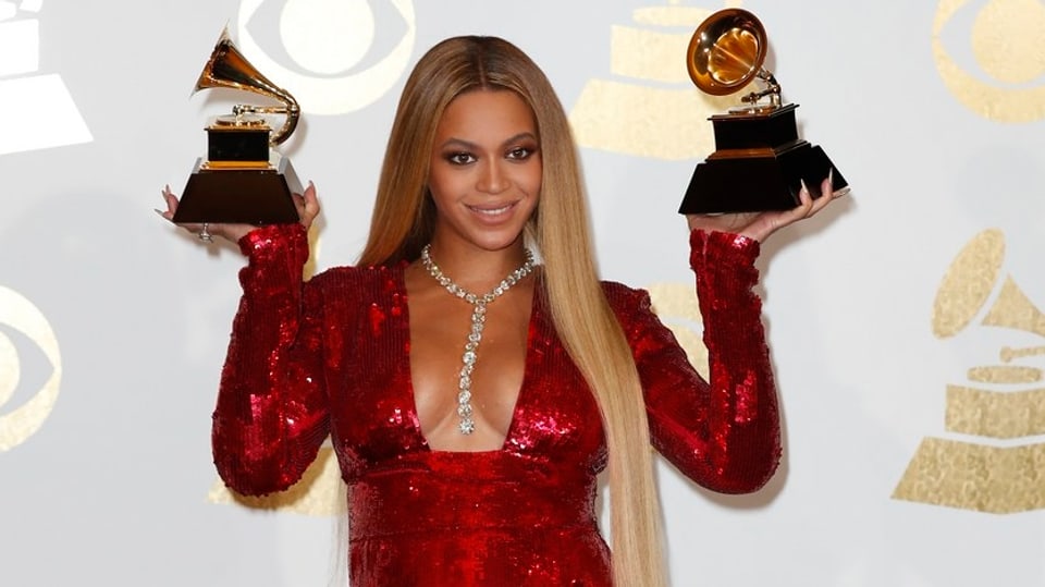 Beyoncé hält Grammy-Auszeichnungen in den Händen.