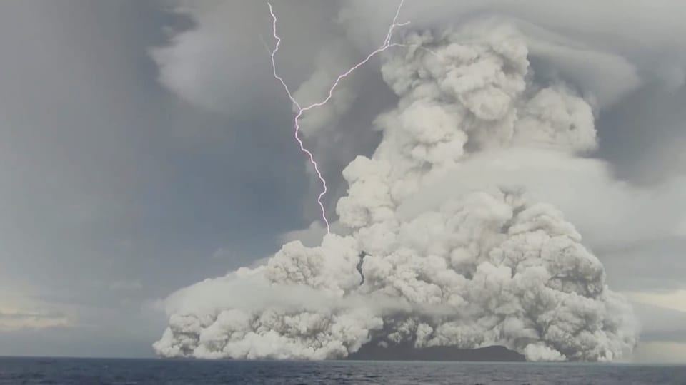 Über einem Vulkan ist eine grosse graue Aschewolke zu sehen.