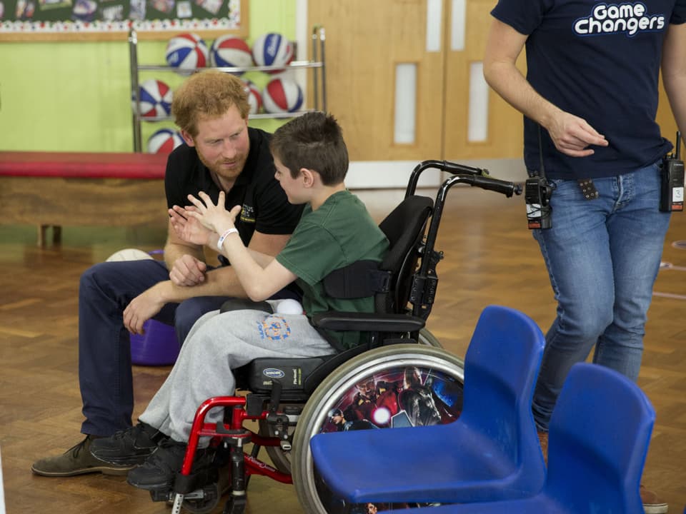 Prinz Harry im Gespräch mit einem, im Rollstuhl sitzenden Jungen