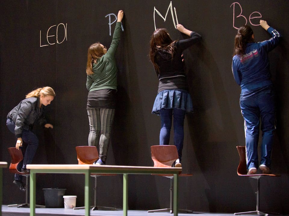 Schüler schreiben auf Riesen-Wandtafel