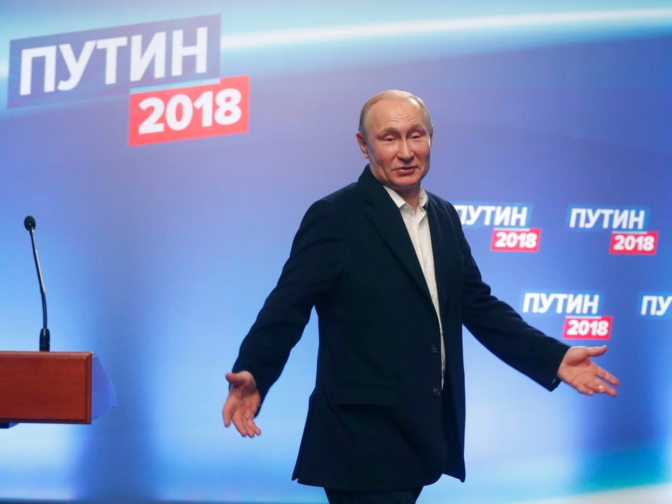 Putin auf einem Podium in einer entschuldigenden Geste.