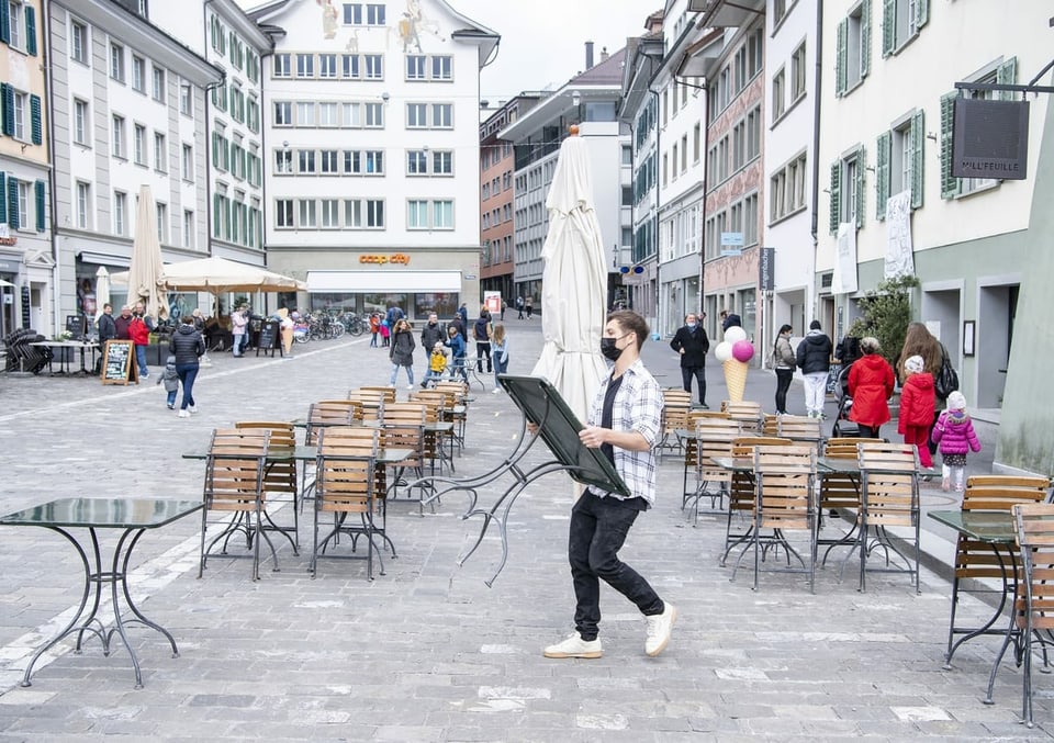 Person trägt einen Tisch auf einen Platz in Luzern.