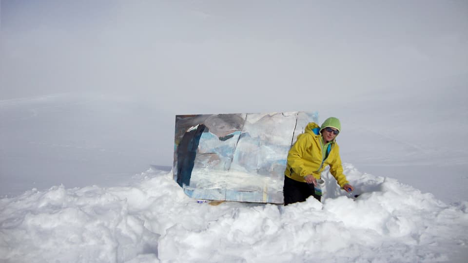 Eine Künstlerin malt im Schnee.