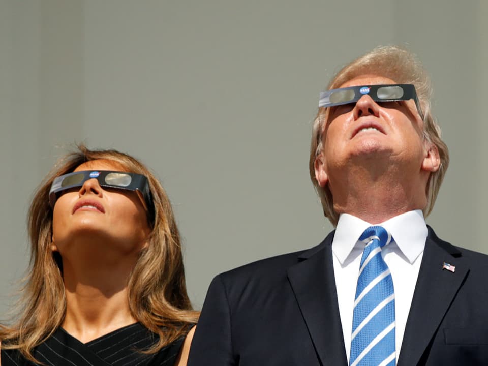 Amerikanisches Präsidentenpaar blickt nach oben mit Sonnenbrillen.