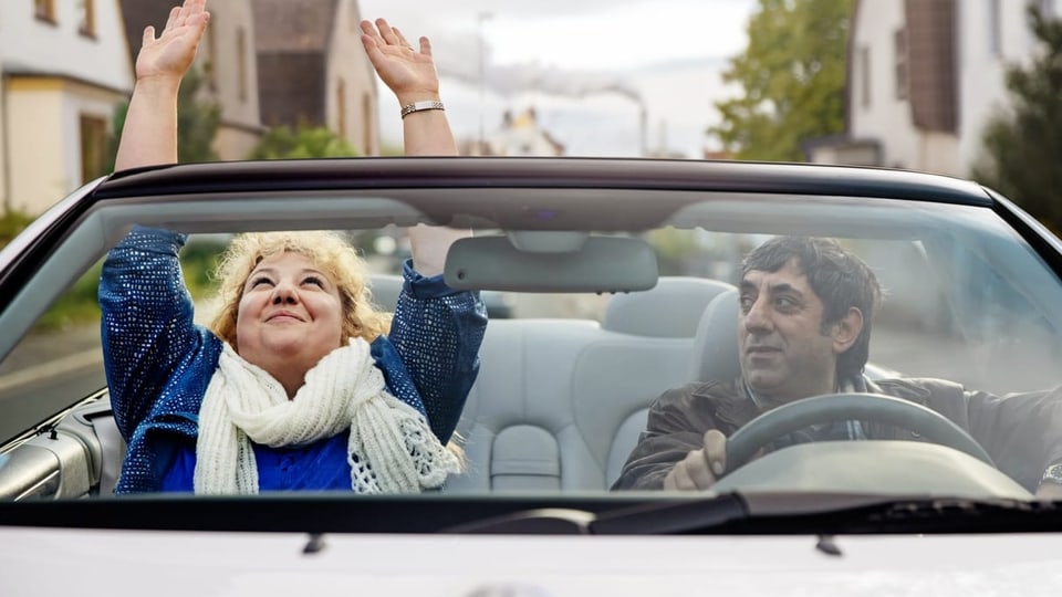 Ein Mann und eine Frau in einem offenen Wagen.