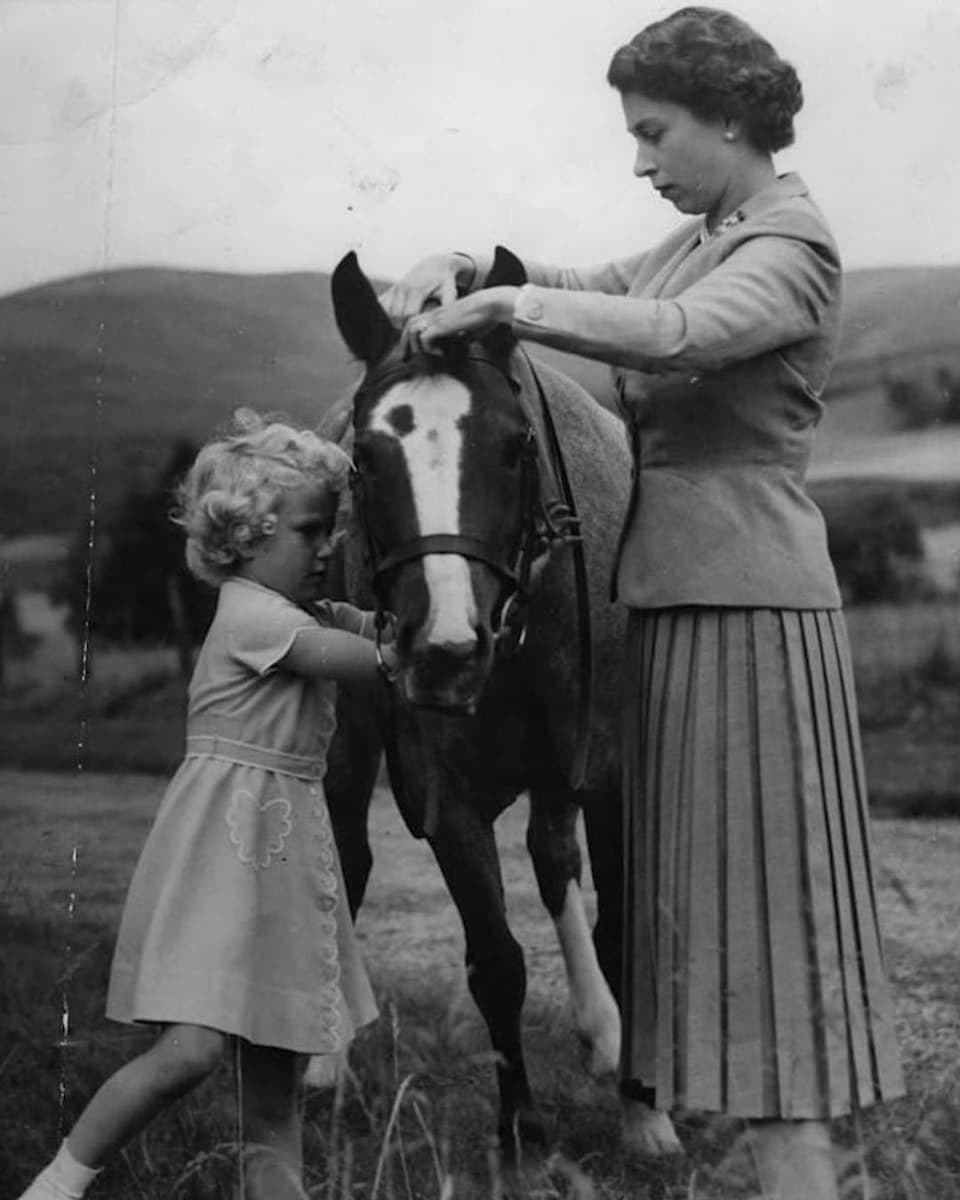 Kind und Frau kümmern sich um Pferd