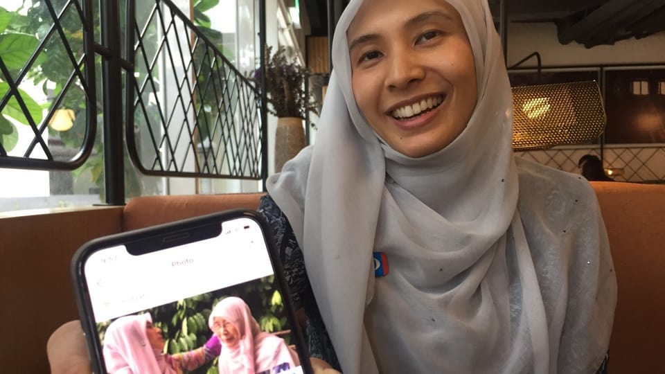 Nurul Izzah Anwar hält lächelnd ihr Smartphone in die Kamera