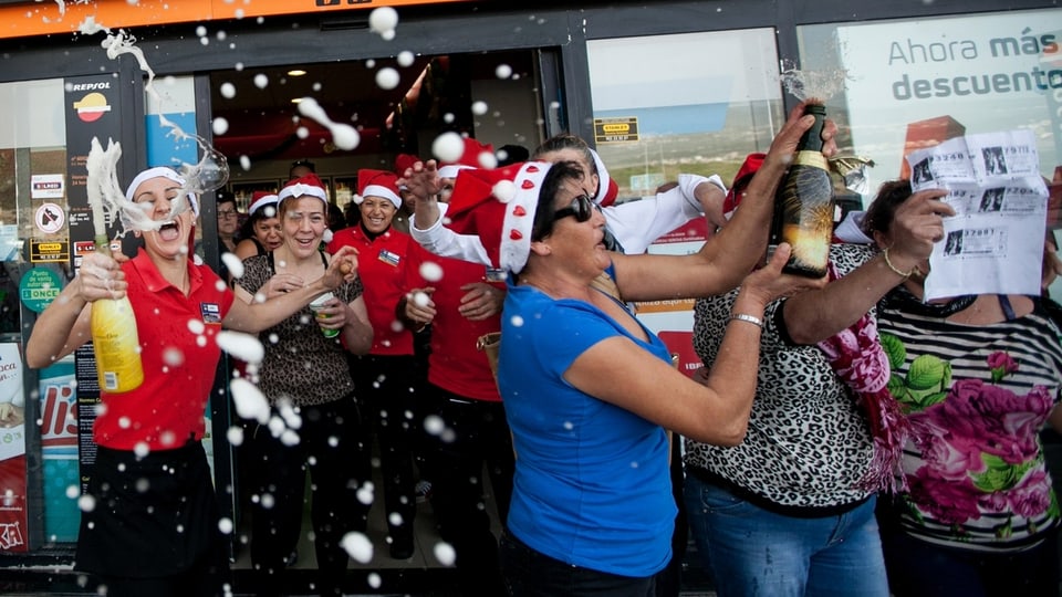 Frauen mit Losen, Nikolaushüten und Champagnerflaschen feiern ausgelassen.
