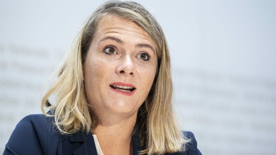 eine Frau spricht vor einer weissen Wand