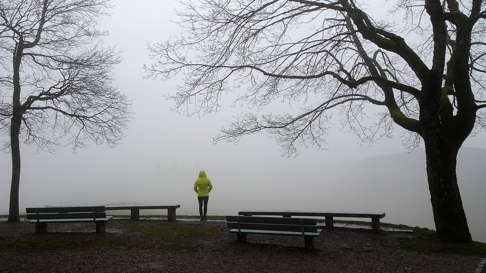 Eine Person steht im Nebel